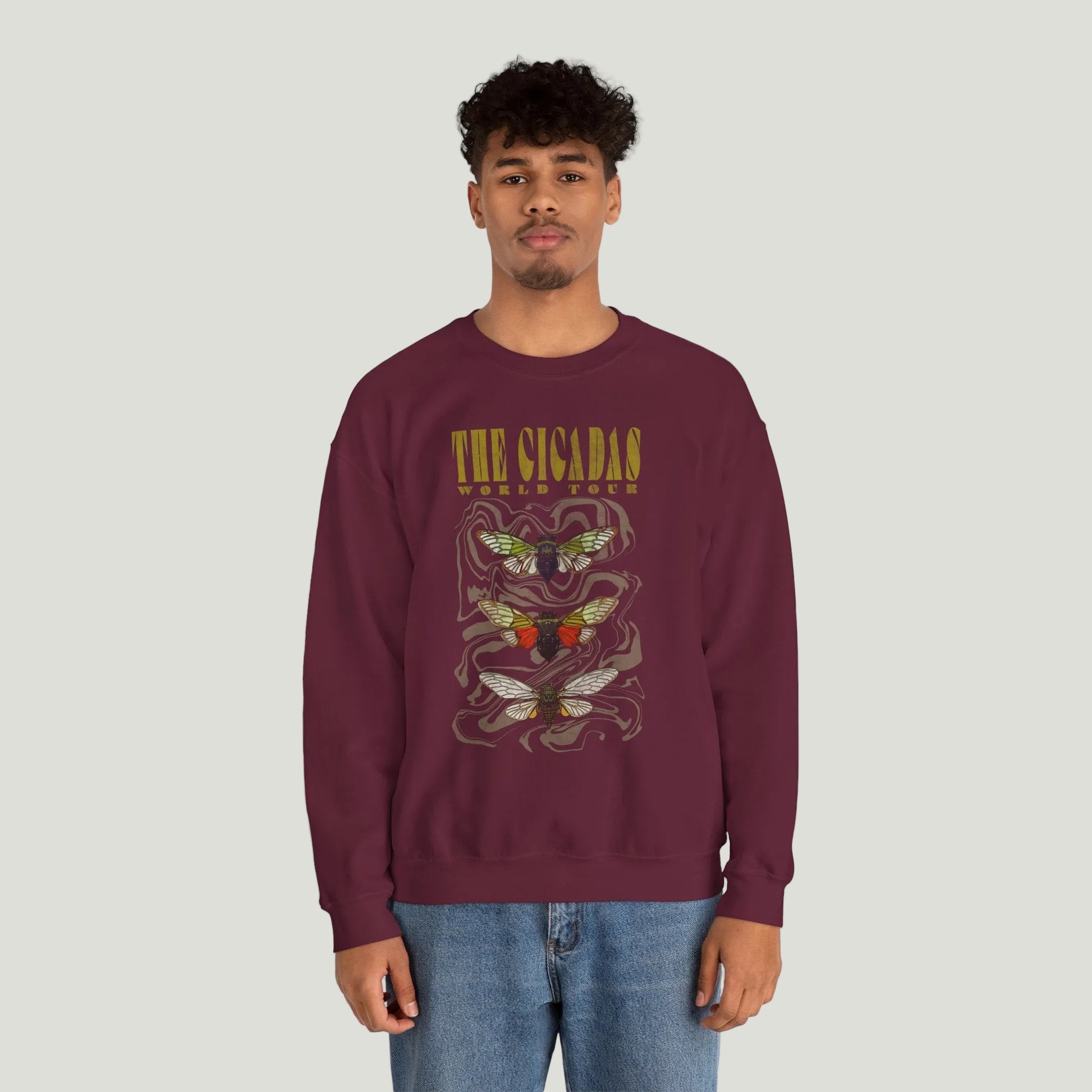 Person wearing a maroon sweatshirt with graphic design on a white background