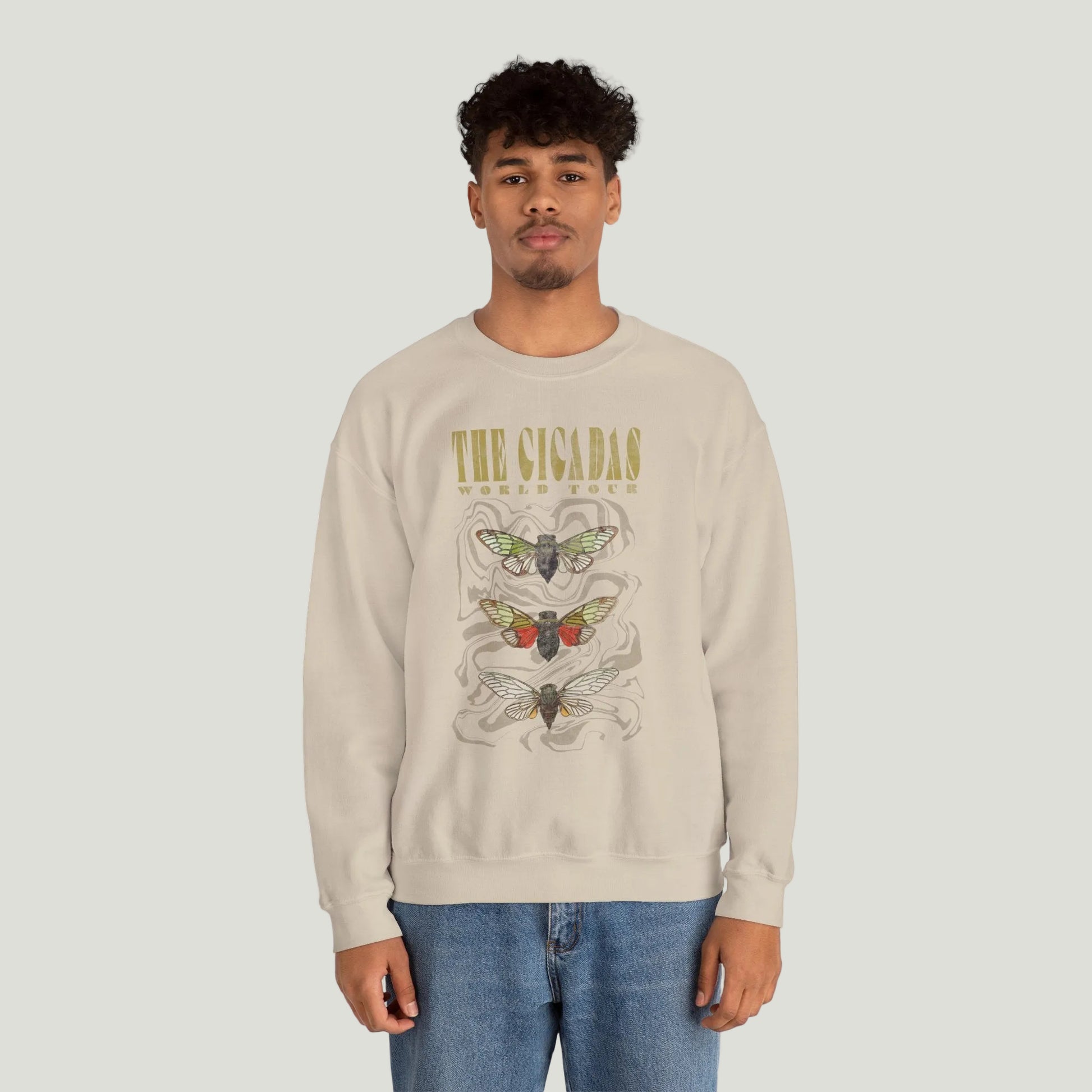 Person wearing a beige sweatshirt with cicadas graphic design.