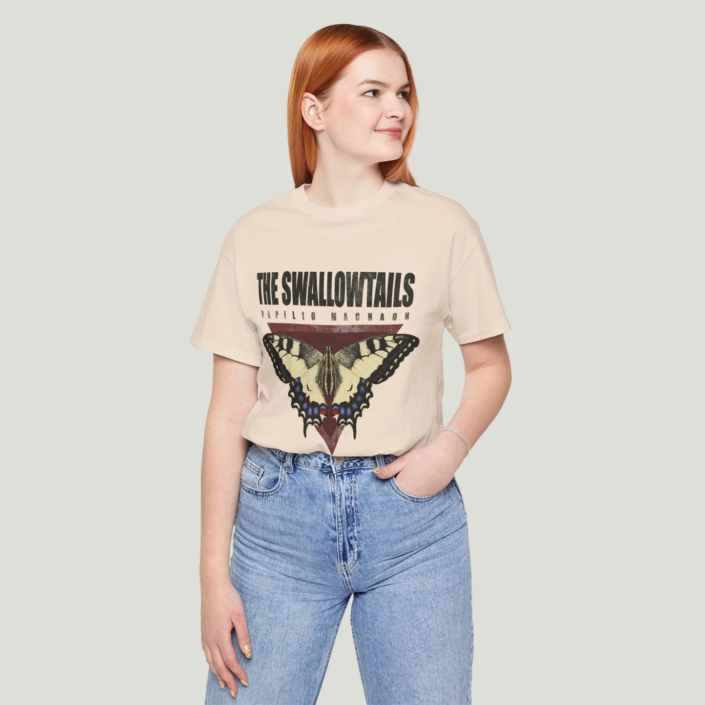 Person wearing a beige t-shirt with butterfly graphic and text on a white background